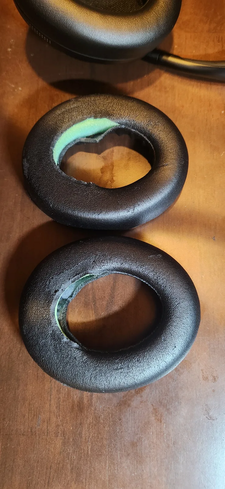 Two old NC700 ear pads, torn on the surface with the cushioning material showing