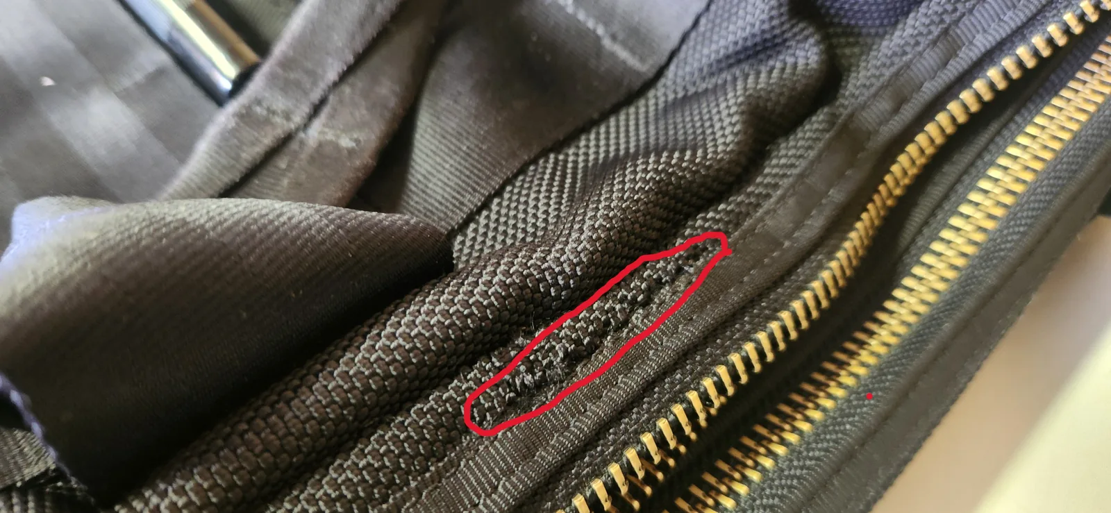 自分で縫って補修した箇所のアップ。赤丸で囲んだ部分が手縫いの跡