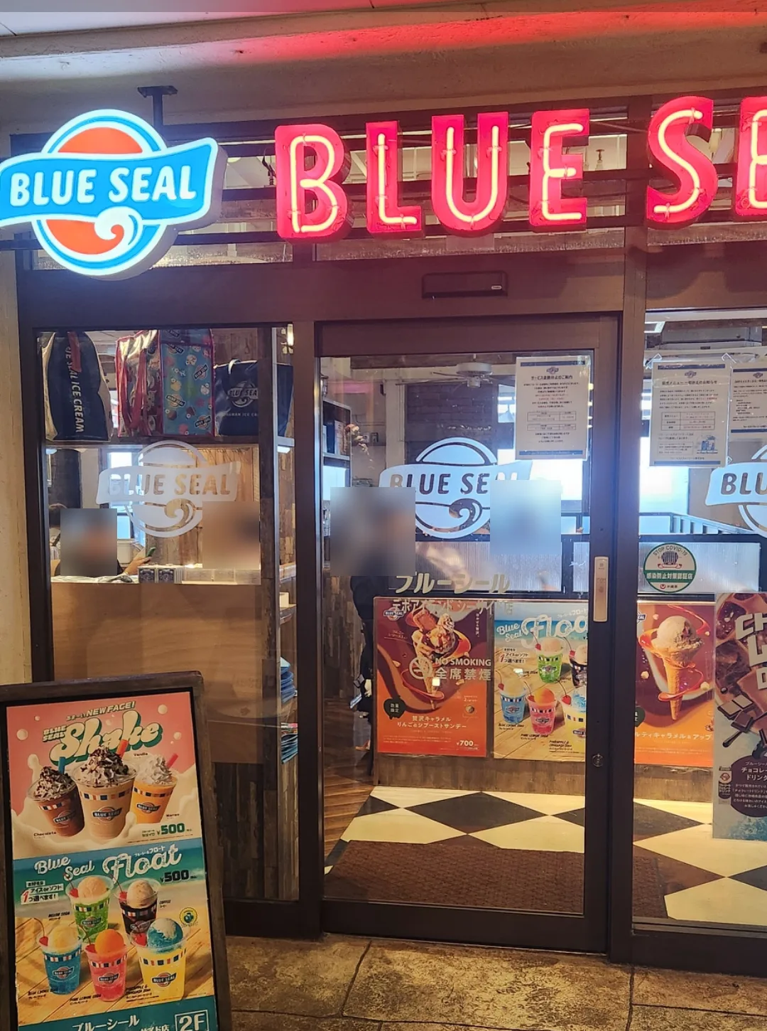 The storefront of the Blue Seal Depot Island Seaside shop. A neon sign and menu board