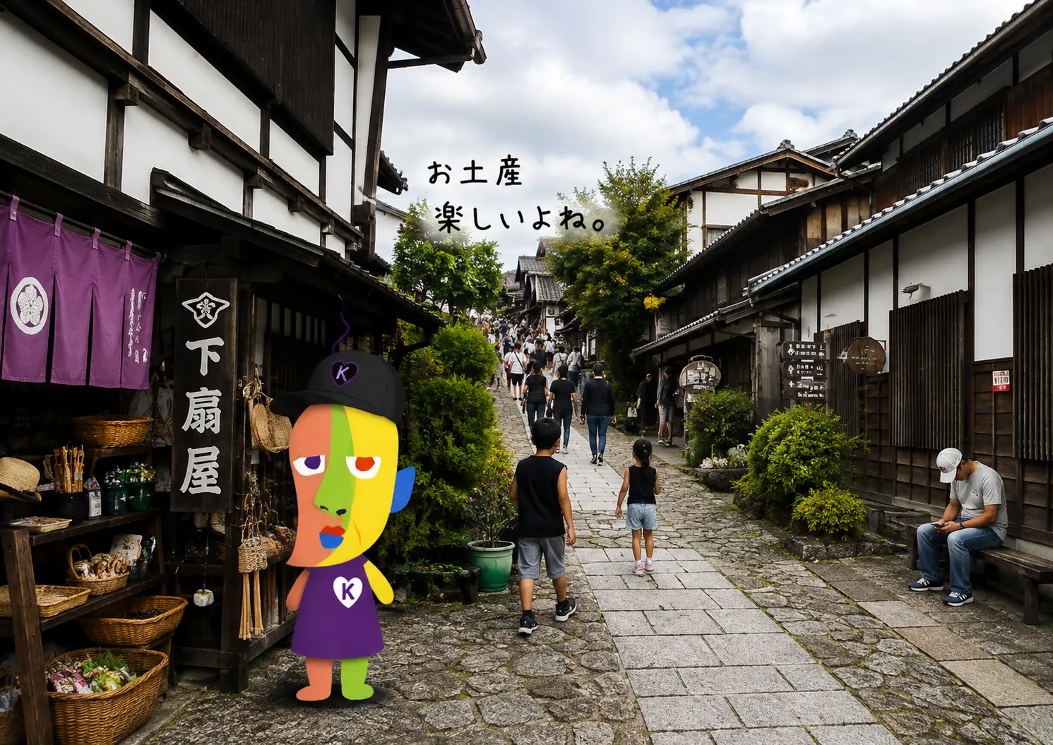 お土産屋さんの店先で立ち止まるKAZUKIN。奥に続く石畳の坂道と観光客の姿。「お土産 楽しいよね。」の手書き文字。