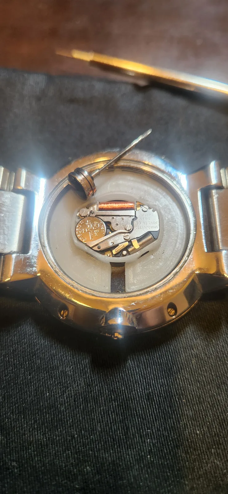 The NIXON THE CAPITAL with its crown pulled out. The removed crown sits on top of the movement